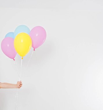 El ele tutuşan balonlar. Tatil konsepti. Renkli parti balonları arka planı. Beyazda izole edilmiş. Boşluğu kopyala