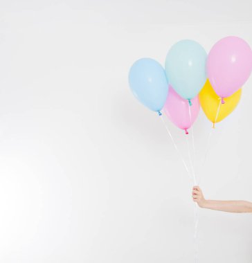 El ele tutuşan balonlar. Tatil konsepti. Renkli parti balonları arka planı. Beyazda izole edilmiş. Boşluğu kopyala