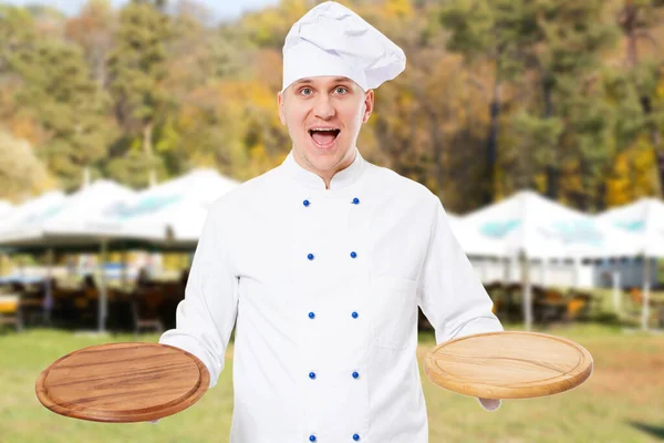 Happy teen male chef with pizza boards mock up