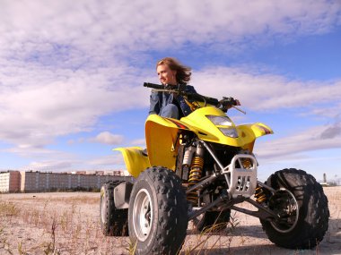 güzel sarışın spor quadrocycle şehir nadym arka plan üzerinde üzerinde.