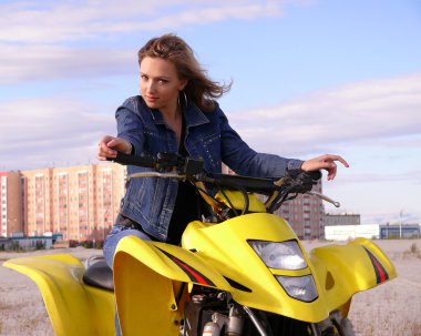 güzel sarışın spor quadrocycle şehir nadym arka plan üzerinde üzerinde.