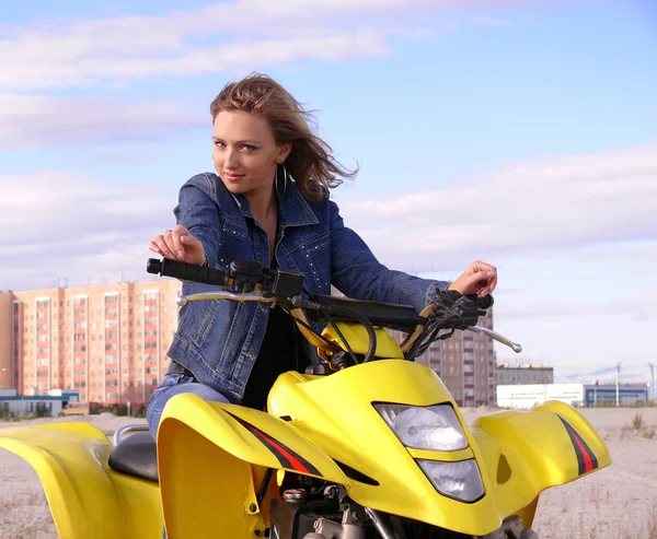 güzel sarışın spor quadrocycle şehir nadym arka plan üzerinde üzerinde.