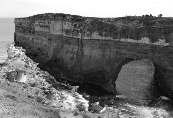 The rocky arch and surf, monochrome. Great Ocean Road, Australia, Victoria, National park. — Stock Photo, Image