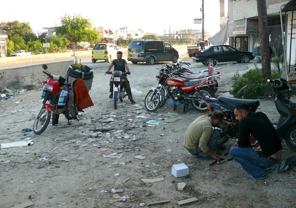 Unfamiliar, Turkish men repairing motorcycles. Trade and repair of motorcycles - in Syria, Latakia November 4, 2008. — Stock Photo, Image