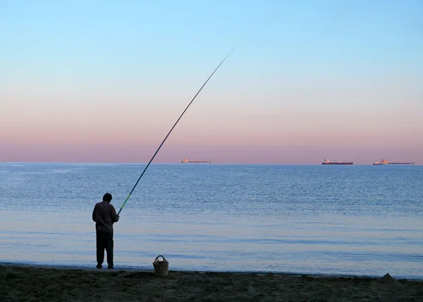 Unknown man catches a fish. The Mediterranean coast of Syria, Baniyas - November 5, 2008. — Stock Photo, Image