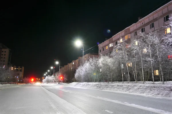 Nuevo Año - la fiesta. Decoraciones festivas en la calle. Edificio y árboles bellamente iluminados. Muy al norte, Nadym. . — Foto de Stock