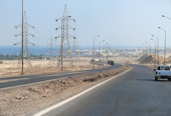 La route du Caire à Hurghada dans le canal Suetsky, Egypte - 11 novembre 2008. Voitures conduisant sur la route. Installations pétrolières loin . — Photo