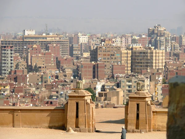 Neznámý muž u brány města Káhiry. pohled na město. architektonické městské budovy. — Stock fotografie