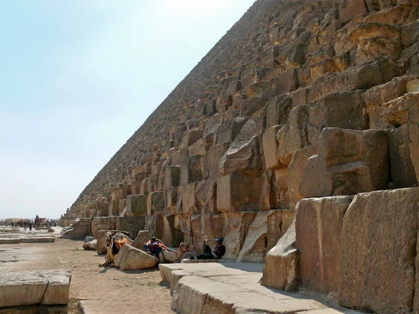 Ägyptische Schritt Pyramide Nahaufnahme. zwei unbekannte Männer mit Kamelen, die im Schatten der Pyramiden ruhen. Unbekannte Touristen in der Nähe der Pyramide. — Stockfoto