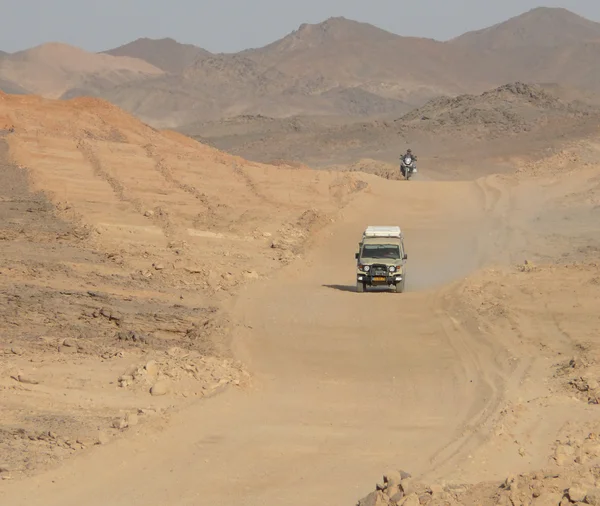 Un uomo sconosciuto alla guida di una moto sulla strada per la jeep a Wadi - Halfa, Sudan - 20 novembre 2008. La strada che attraversa il deserto del Sahara . — Foto Stock