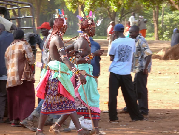 Marsabit, kenya - 27 november 2008: marknaden. obekanta män av den stam tsonga i nationella klänning. obekanta byborna gå om sin verksamhet. träd i bakgrunden. — Stockfoto