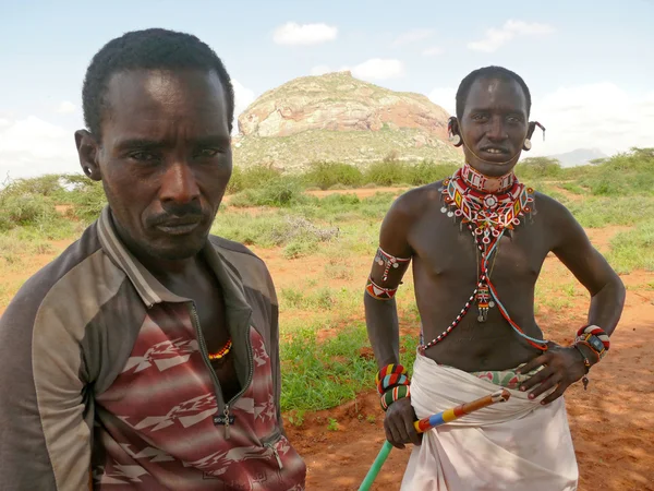 ISIOLO, KENYA - 28 NOVEMBRE 2008 : Deux hommes inconnus de la tribu Tsonga en gros plan. Des montagnes à l'arrière-plan. Autour des plantes et des arbres . — Photo