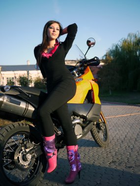 Güzel genç esmer bir motosiklet TH arka plan üzerinde