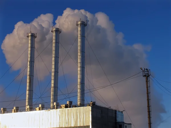 Bâtiment industriel. Tuyau contre le ciel vomissant la fumée . — Photo