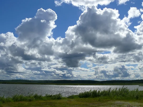 Niedrige große Wolken über dem Fluss. Landschaft Natur. — Stockfoto