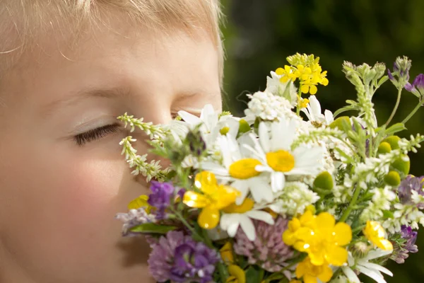若い男の子野生の花の花束の香り ロイヤリティフリーのストック写真