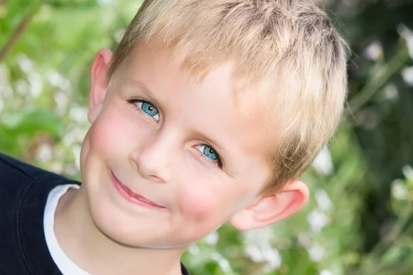 Jeune garçon souriant dans le jardin — Photo