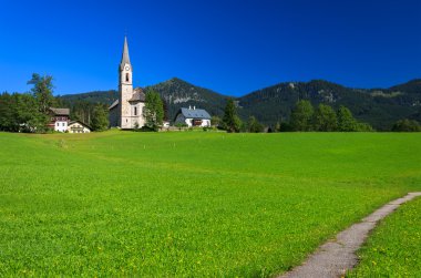 dağ yolu üzerinde kilise uzakta ile yeşil çayır-Alp Köyü