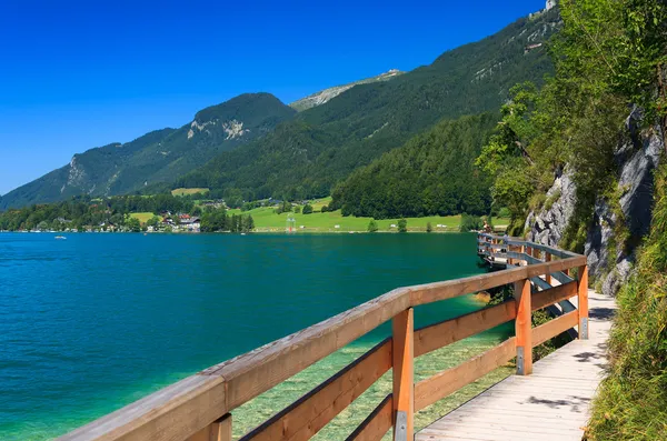 Wooden walkway along beautiful Wolfgang lake in the Alps Mountains — Stock Photo, Image