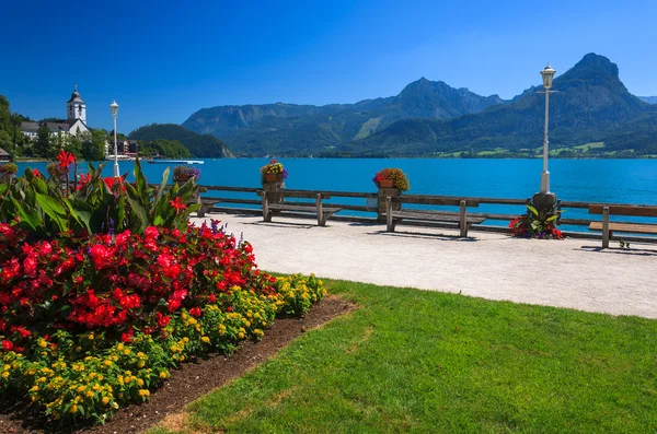 Promenade with flowers and benches on beautiful lake — Stock Photo, Image