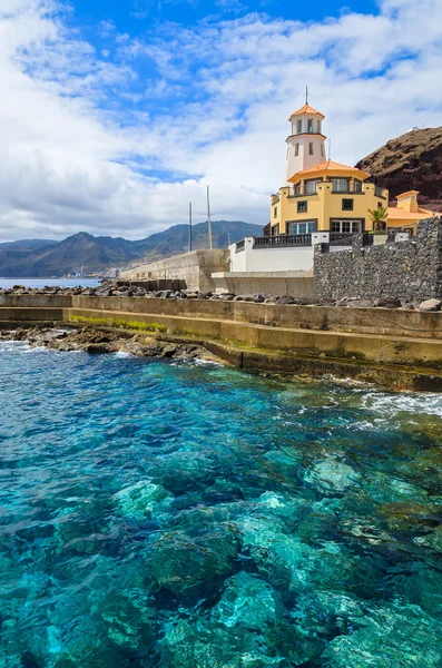 Agua de mar turquesa con faro en la orilla — Foto de Stock