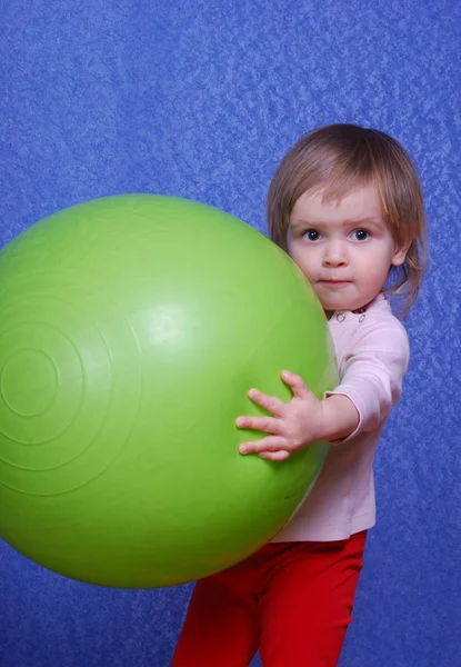 Criança com bola, retrato sobre um fundo azul — Fotografia de Stock