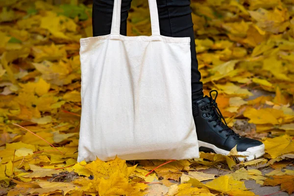 Empty reusable canvas tote bag mockup. Natural canvas eco-friendly shopper bag in girl\'s hand. Mockup for presentation of design or brand