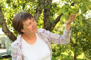 Bahçedeki orta yaşlı kadın.