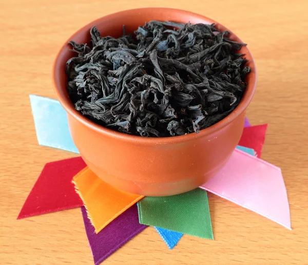 Tea cup with dry black tea — Stock Photo, Image