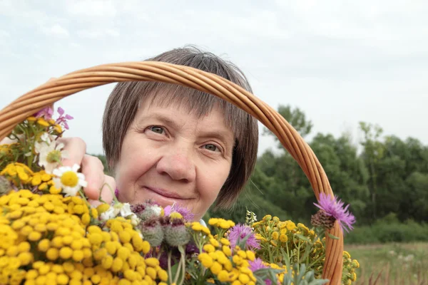 Mulher de idade com flores silvestres — Fotografia de Stock