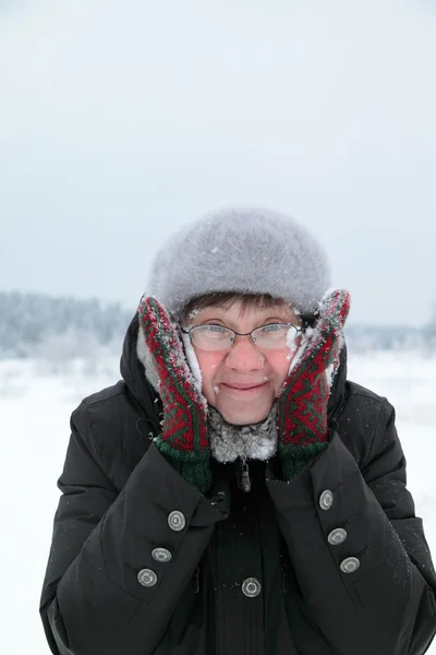 Woman rubbing snow person — Stock Photo, Image