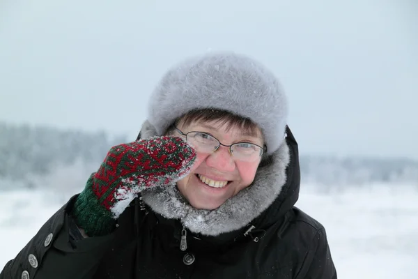 Woman rubbing snow person — Stock Photo, Image