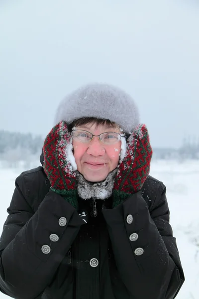 Woman rubbing snow person — Stock Photo, Image