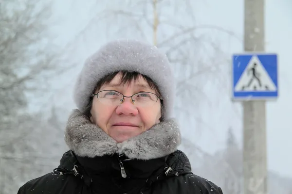 Vrouw onder teken voetgangersoversteekplaats, winter. — Stockfoto
