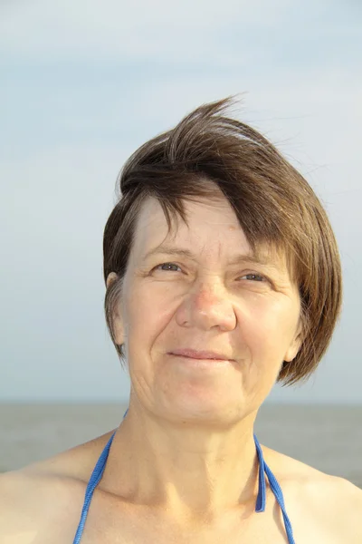 Glückliche Frau mittleren Alters auf dem Hintergrund der Ostsee — Stockfoto