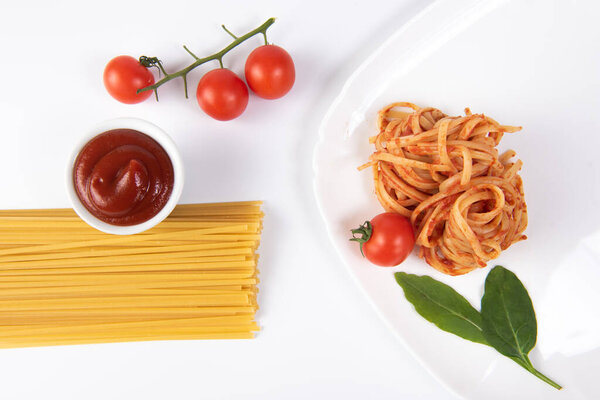 pasta with tomato sauce and basil on white dish.