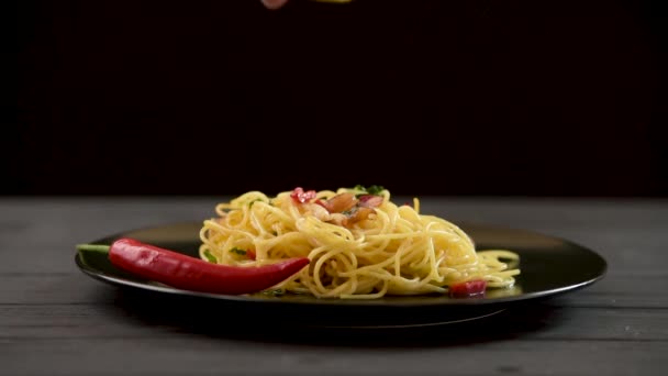 Homemade pasta is sprinkled with lemon juice. Spaghetti aglio olio — стоковое видео