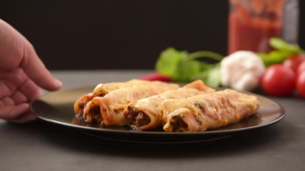 काळ्या प्लेटवर एन्किलाडोसची पारंपारिक मेक्सिकन डिश. गरम डिश वाफ येतो — स्टॉक व्हिडिओ