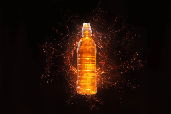 Isotonic energy drink. Orange bottle on black background with splashes of orange liquid — Stock Photo, Image