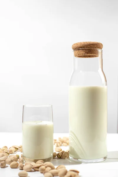 Pistachio milk the glass next to bottle of milk and pistachios — Fotografia de Stock
