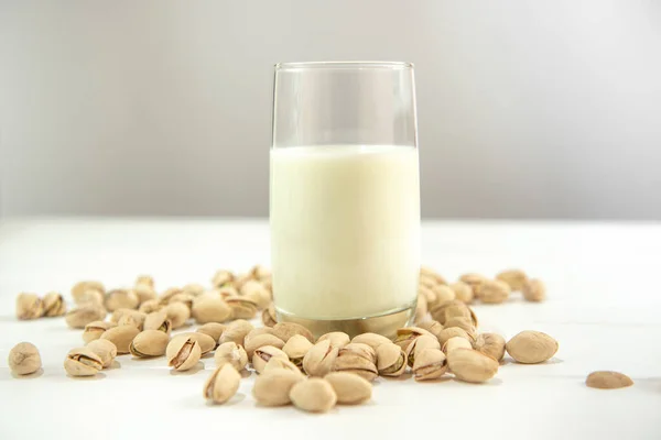 A glass of pistachio milk on a light background — Fotografia de Stock