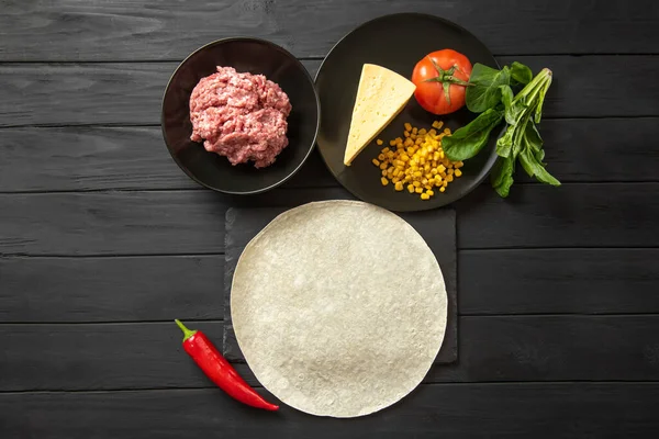 Ingredients for encheladas on a black background meat, pita, tomato, peppers and basil. Flat lay — Photo