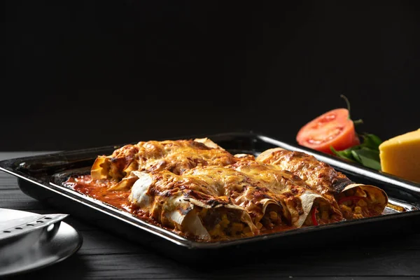 Latino American Food. Enchiladas cooked and standing on a black background — Photo