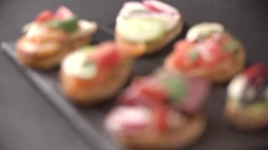 Şef masaya pişmiş İtalyan aperatifi servis eder. Kaykayda geçen bir şatafat. Sağlıklı bir vejetaryen ve vejetaryen aperatifi. Yakın plan...