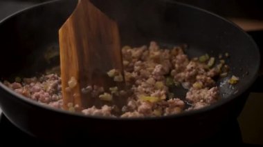 Kızarmış kıyma tahta kaşıkla karıştırılır..
