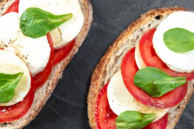 Domatesli, mozarella ve fesleğenli Caprese bruschetta tostu. Metnin için en üstte boşluk var. İtalyan tostu.