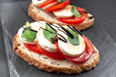 Domatesli, mozarella ve fesleğenli Caprese bruschetta tostu. Metnin için alanı olan en üstteki görünüm.