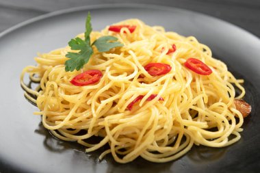Siyah tabakta geleneksel İtalyan spagetti agliosu. Kapat.