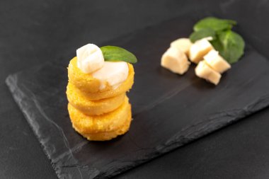 Bir yığın kızarmış Polenta Diski, matzarella peyniri ile koyu arkaplan üzerine yazdığınız metin için kopyalama alanı.