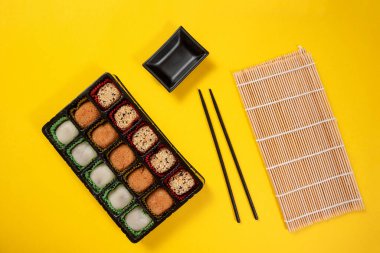 Japon tatlı paketi sarı arka planda. Japon dondurması ve pirinç hamuru. Geleneksel Japon tatlıları sarı arka planda